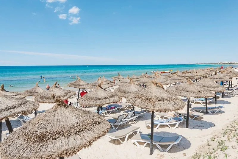 Peščena plaža s slamnatimi senčniki pred hotelom Bella Vista