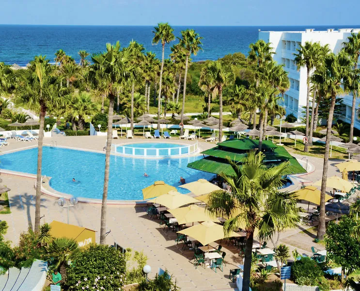 Zunanji bazen hotela Tropicana Club obdan s palmami in hotelskimi zgradbami