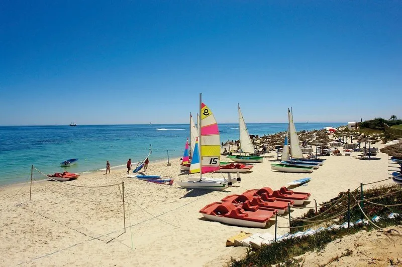 Peščena plaža s senčniki in opremo za jadranje