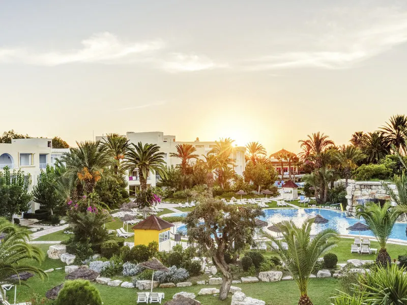 Sončni zahod nad bazenskim kompleksom in vrtovi hotela Africana